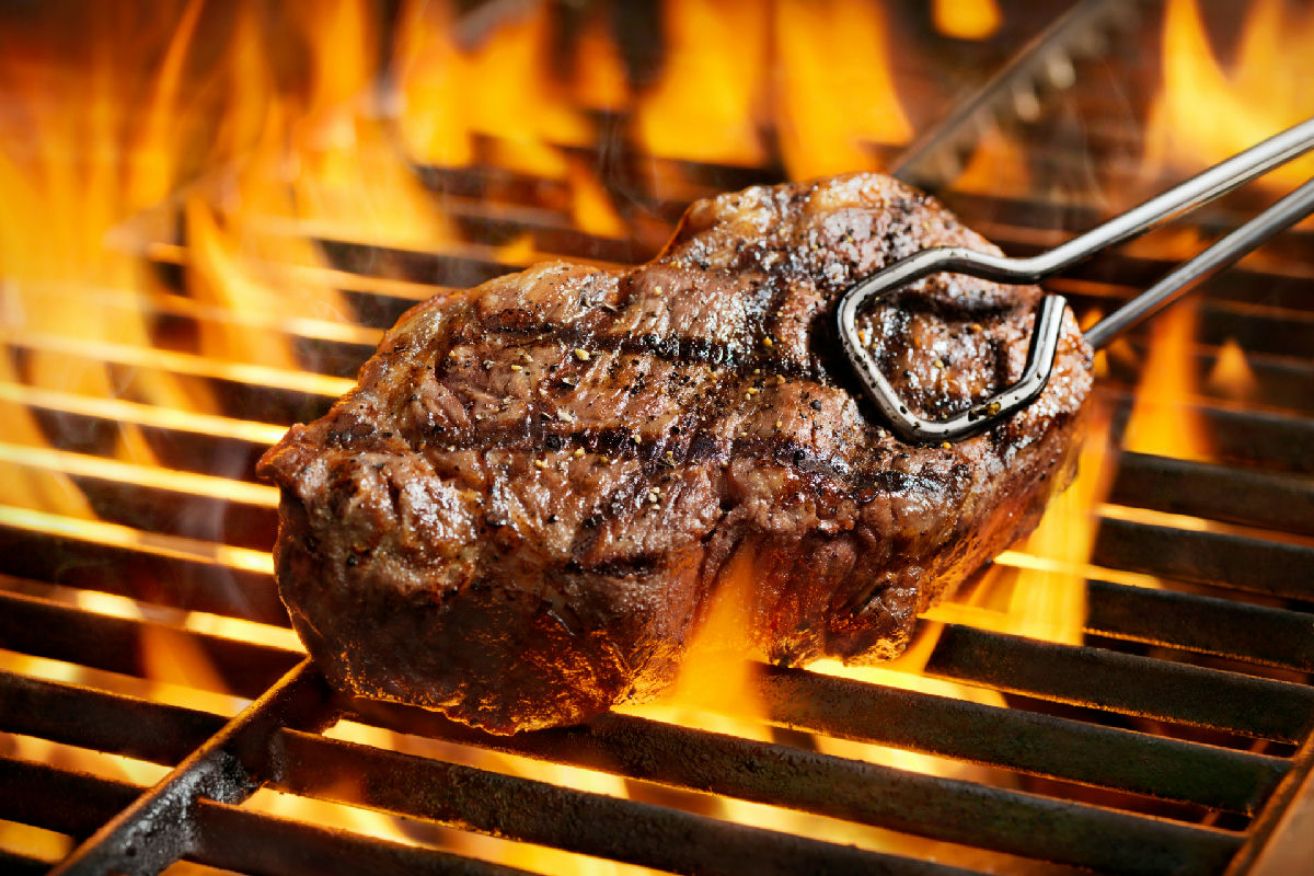 Steak über offener Flamme auf dem Grillrost