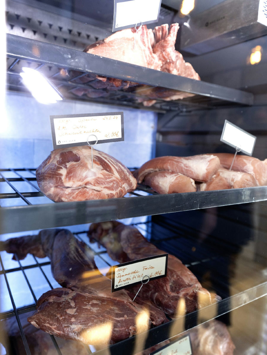 Fleisch im Dry Ager mit handgeschriebenen Preisschildern